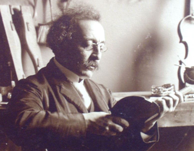 Alfredo Bensaúde holding a violin in his studio
